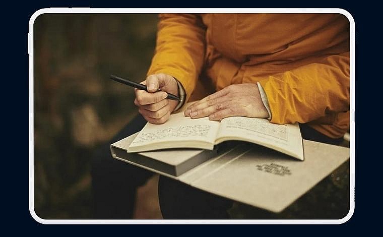 Man writes in a notebook.