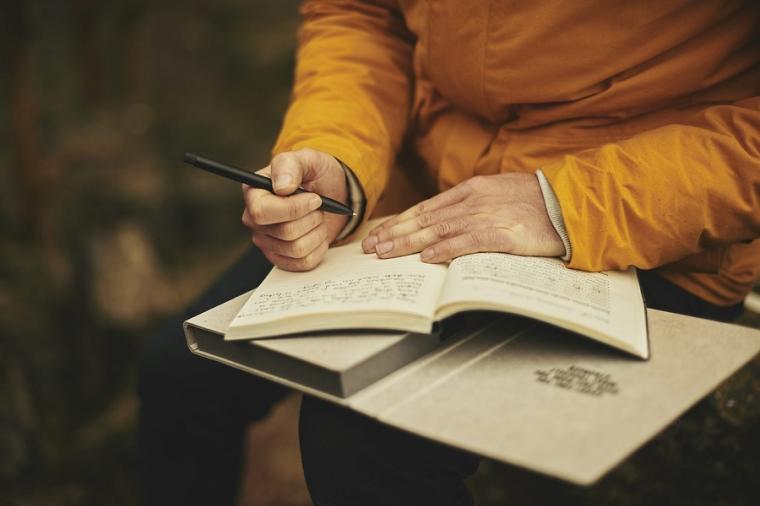 Man writes in a notebook.