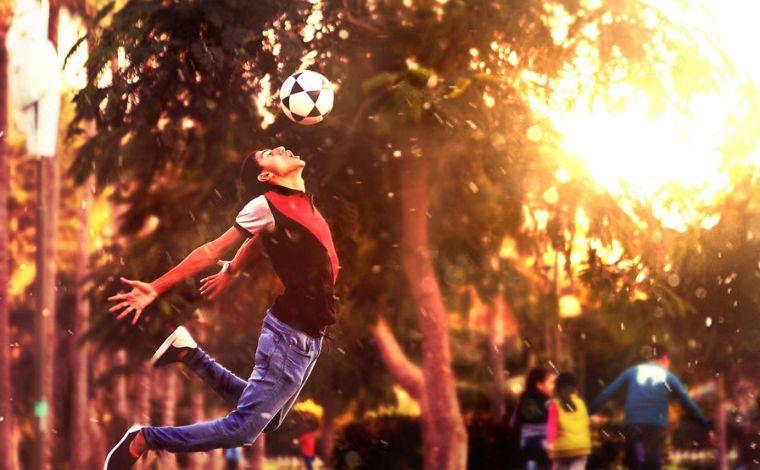 A young man jumps up for a header