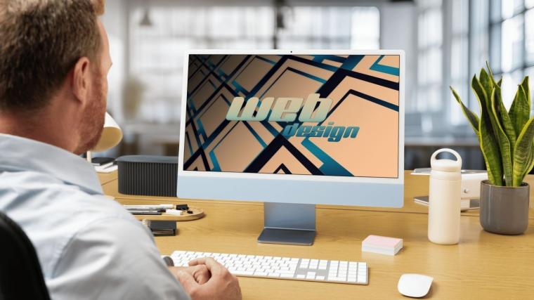 Man sits at his desk and looks on his monitor.